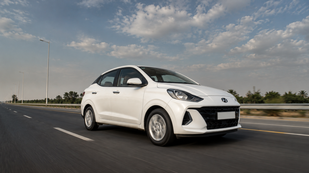 "Hyundai Aura CNG सेडान हाईवे पर स्टाइलिश ड्राइविंग शॉट"
