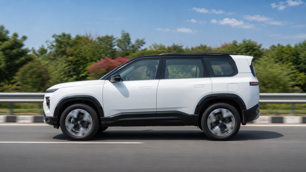 हाईवे पर चलती हुई सफ़ेद Tata Sierra EV इलेक्ट्रिक कार का साइड प्रोफाइल व्यू